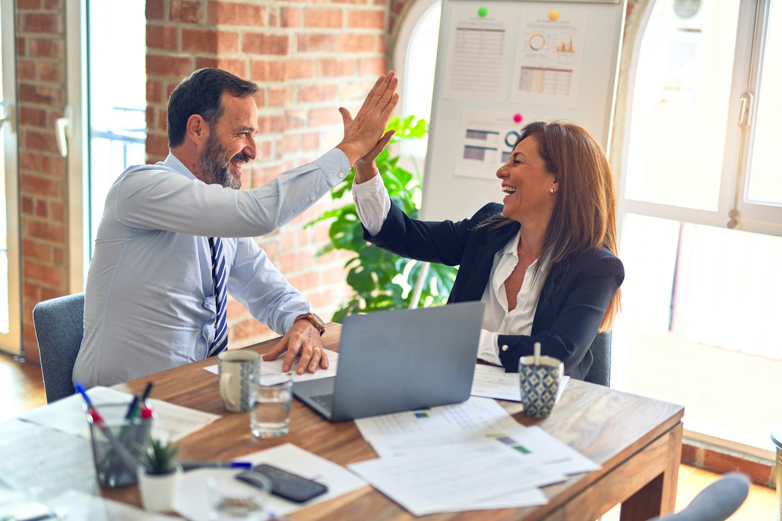 two business professionals high fiving 